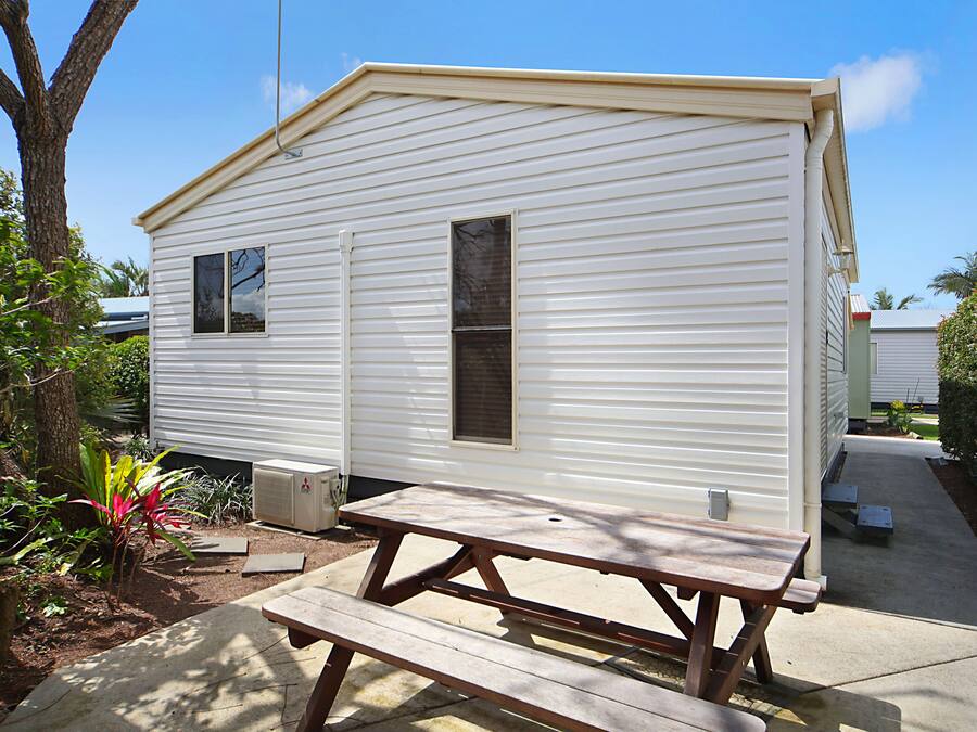 A mobile home with a picnic table in front.