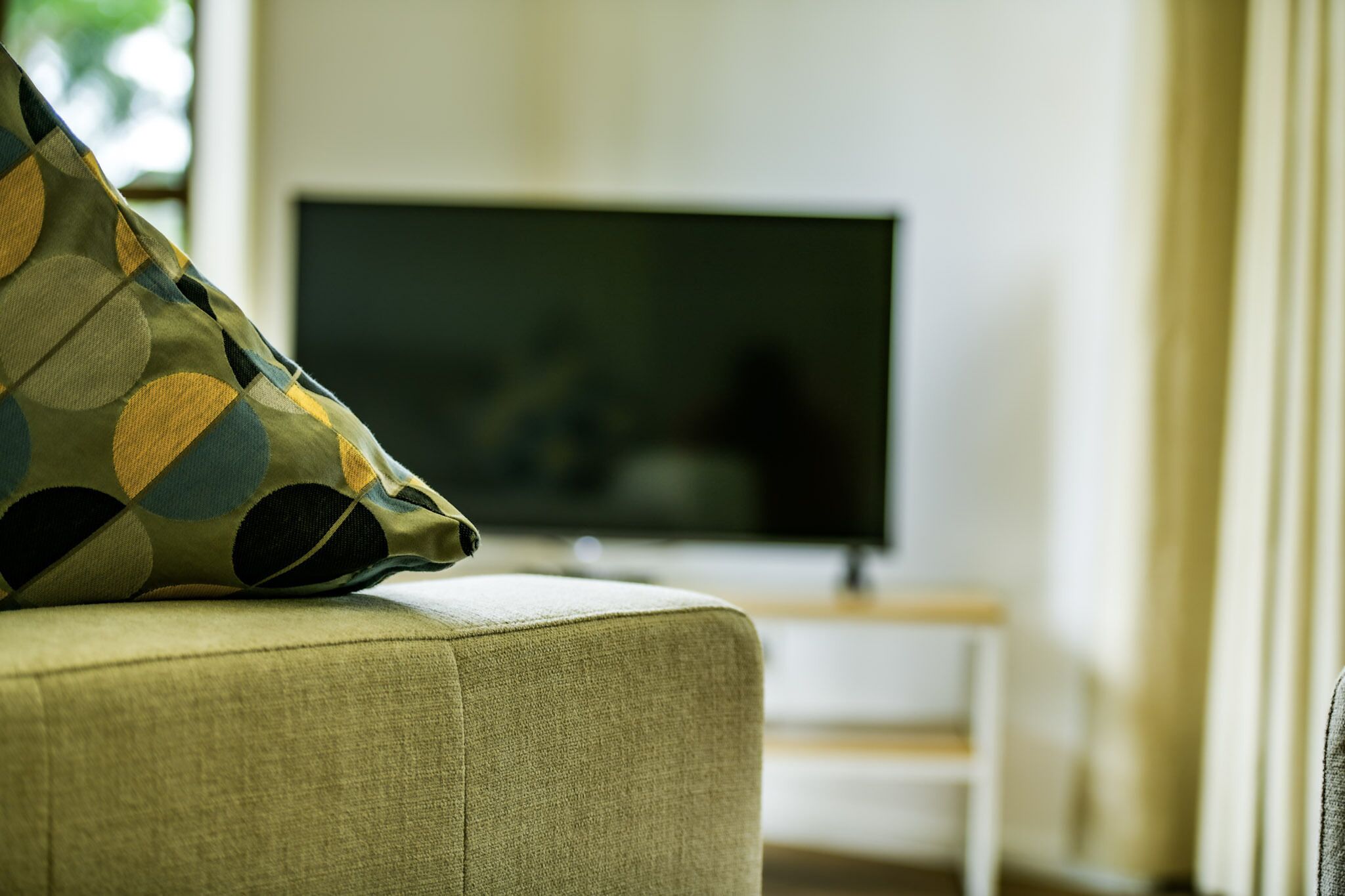 A living room with a sofa, a television, and a small table.