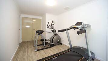 Ein Heimfitnessraum mit Laufband, Crosstrainer und Hometrainer.