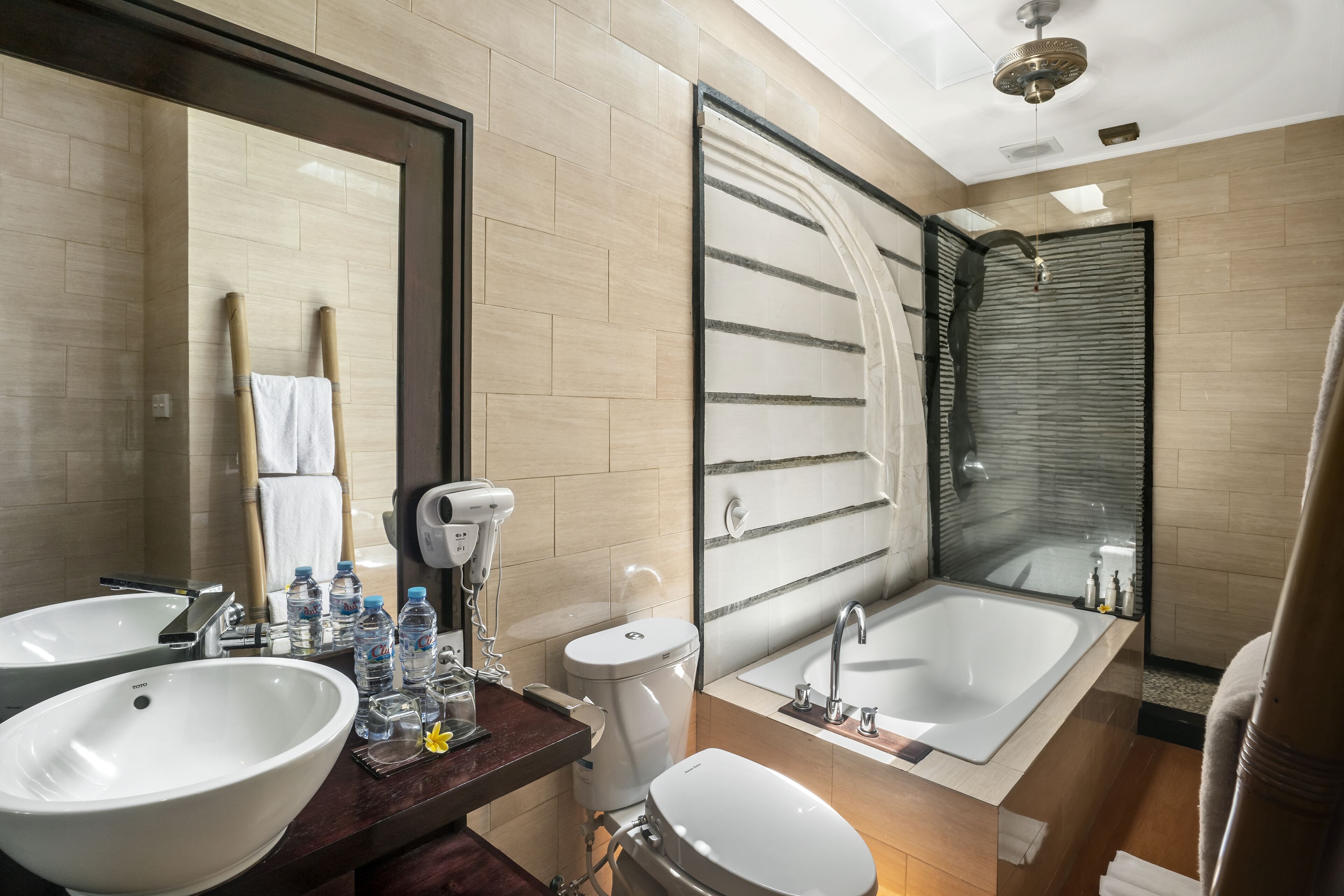 A modern bathroom with two sinks, a large bathtub, and a glass shower enclosure.