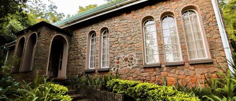 A stone building with arched windows and a stone staircase leading to the entrance.