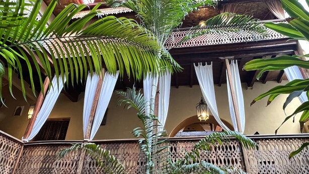 A traditional building with a balcony, wooden lattice railings, and white curtains. - Jafferji House (Zanzibar Town)