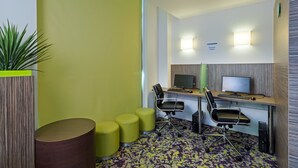 A modern office space with two desks, ergonomic chairs, and a potted plant. - Holiday Inn Express Harlow by IHG (Harlow)
