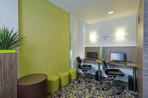 A modern office space with two desks, ergonomic chairs, and a potted plant. - Holiday Inn Express Harlow by IHG (Harlow)