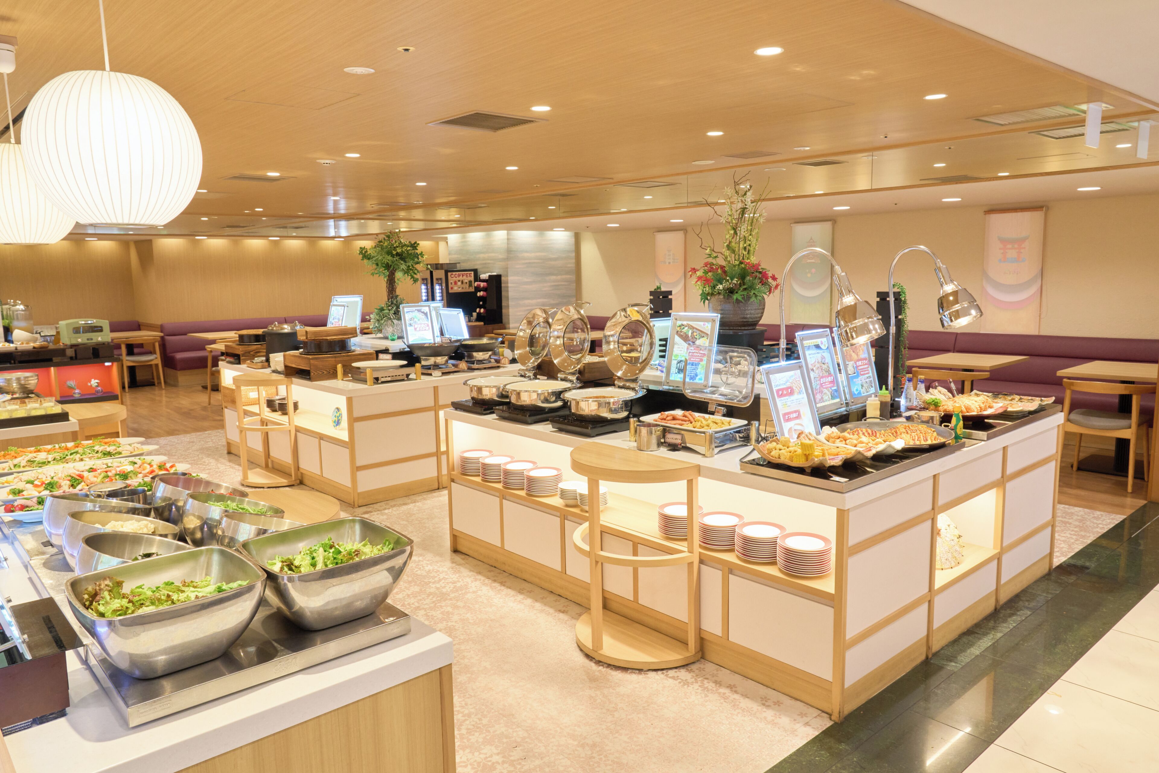 A buffet area with various food stations, seating arrangements, and a coffee station.
