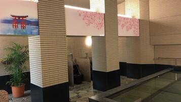 Un interior moderno con paredes de azulejos, suelo de piedra y una fuente de agua.