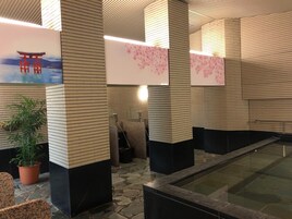 Un interior moderno con paredes de azulejos, suelo de piedra y una fuente de agua.