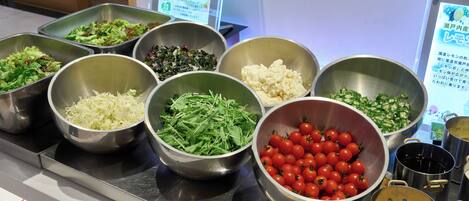 A buffet with various food items in metal bowls.