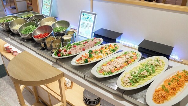 Buffet com diversos pratos, incluindo saladas, carnes e frutos do mar.
