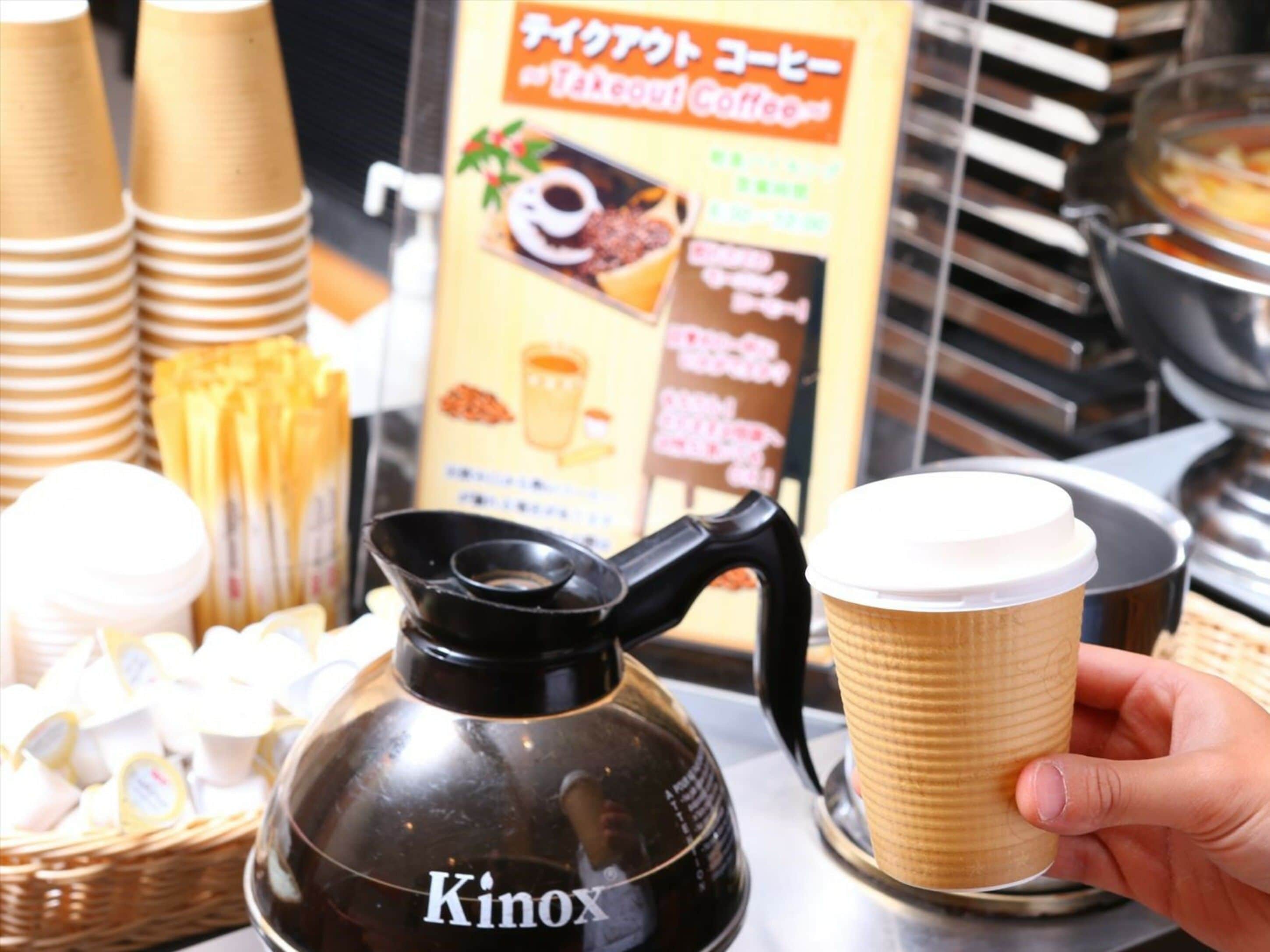 Un café équipé d’une machine à café KINOX, proposant des gobelets à usage unique et affichant son menu sur un tableau.