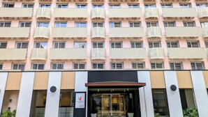 Um hotel de vários andares com fachada moderna, grandes janelas e entrada central.