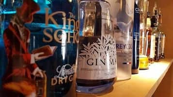 Une étagère contenant différentes bouteilles d’alcool, notamment du gin et de la vodka.