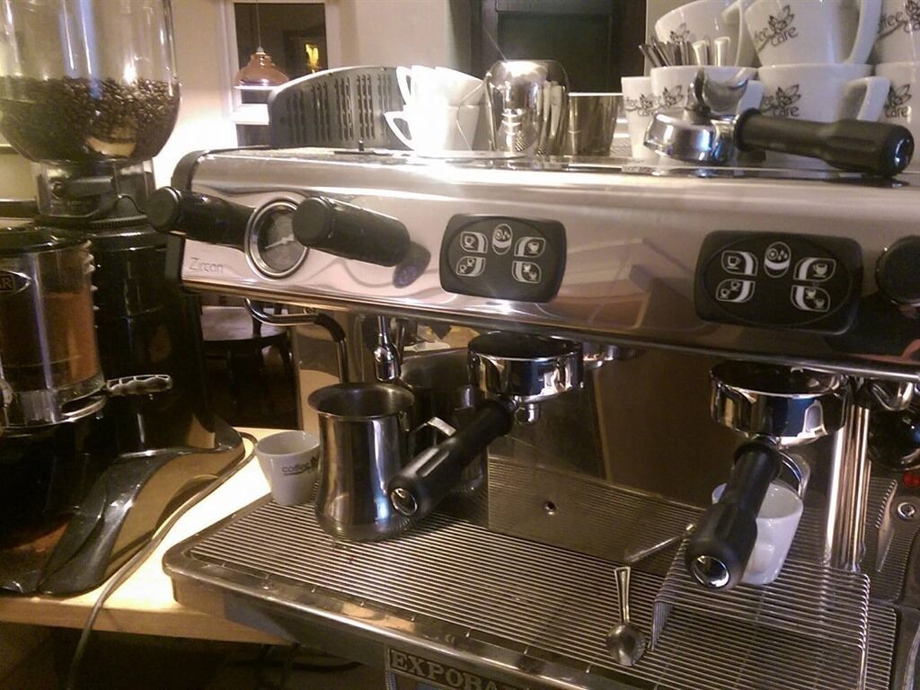 An espresso machine with a digital display and multiple portafilters.