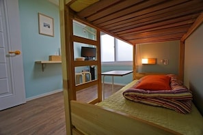 A small, cozy room with a wooden bed, a desk, and a chair. - 710 Guest house Yellow (Busan)