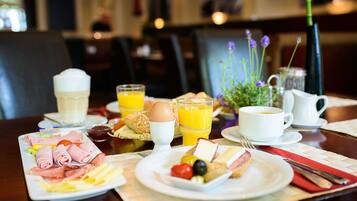 A breakfast setting with plates of food, a pitcher, and glasses of orange juice.