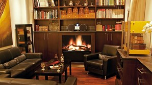 Una sala de estar acogedora con sofás de cuero, una mesa de centro, una chimenea y una estantería llena de libros y adornos.