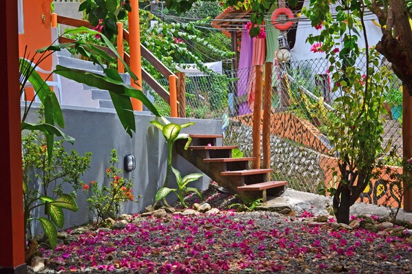 A staircase surrounded by greenery and flowers. - Pousada Aconchego (Cairu)