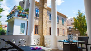A balcony with white columns, wicker furniture, and potted plants. - Artis Domus Relais & Spa (Sorrento)
