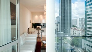 Un apartamento moderno con sala de estar, cocina y un balcón con vistas a la ciudad.