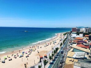 Na praia, espreguiçadeiras, guarda-sóis, toalhas de praia 