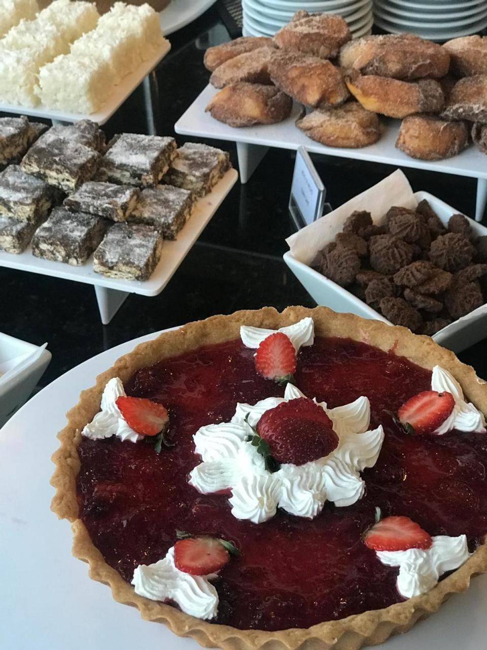 A dessert display with various pastries and a strawberry tart.