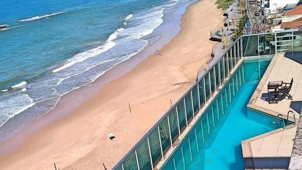 En swimmingpool ved siden af en strand med udsigt til havet.