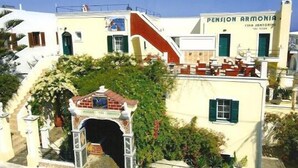Un edificio con un letrero que dice "Pension Armenia" y una escalera que lleva a un área cubierta con un pequeño arco.