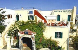 Un edificio con un letrero que dice "Pension Armenia" y una escalera que lleva a un área cubierta con un pequeño arco.