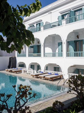 Un edificio blanco con varios balcones y una piscina.