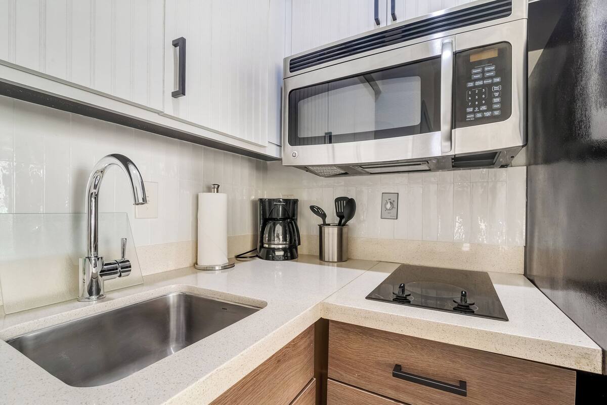 A modern kitchen with stainless steel appliances, a double sink, and a coffee maker.