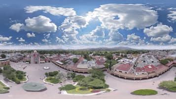 Vista aérea de una plaza histórica con un espacio abierto central rodeado de edificios con techos de tejas rojas.
