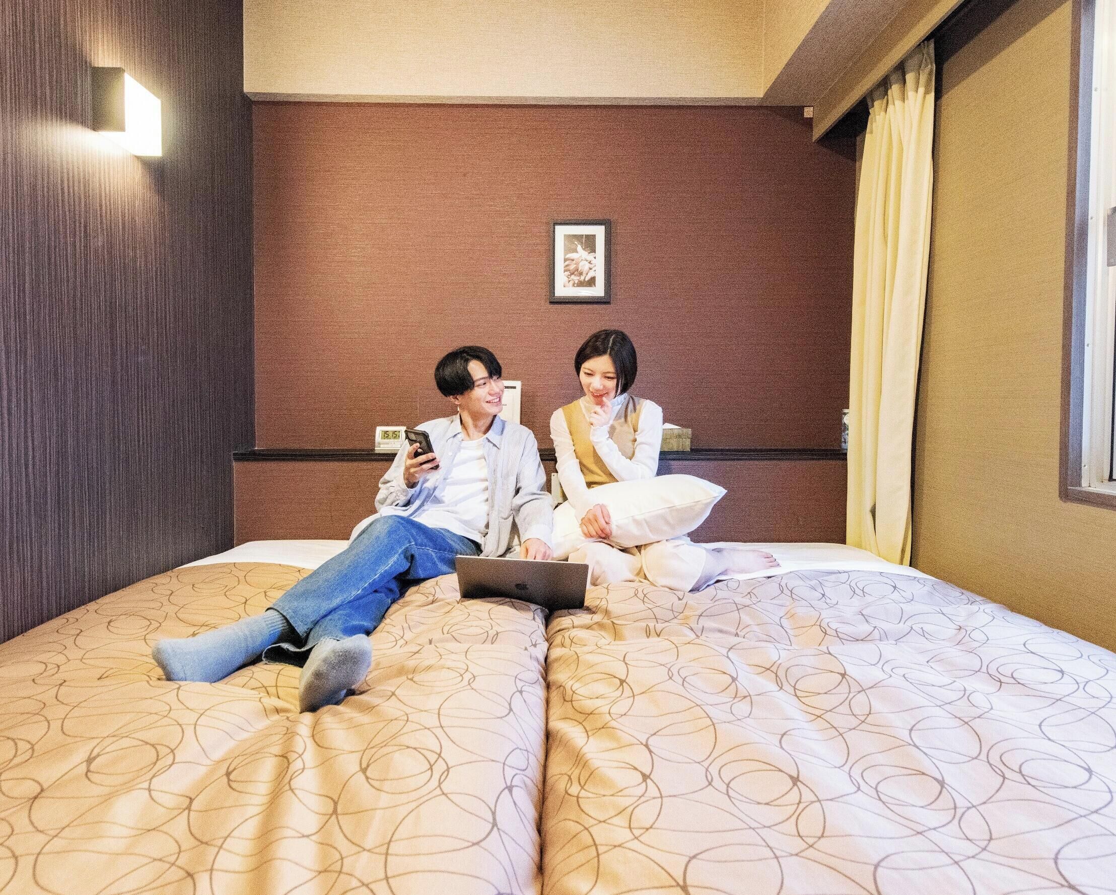 Una habitación de hotel con una cama, un reloj de pared y un cuadro en la pared.