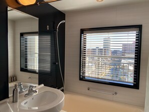 A modern bathroom with a large mirror, a sink, and a window with blinds. - Hotel Trusty Osaka Abeno (Osaka)