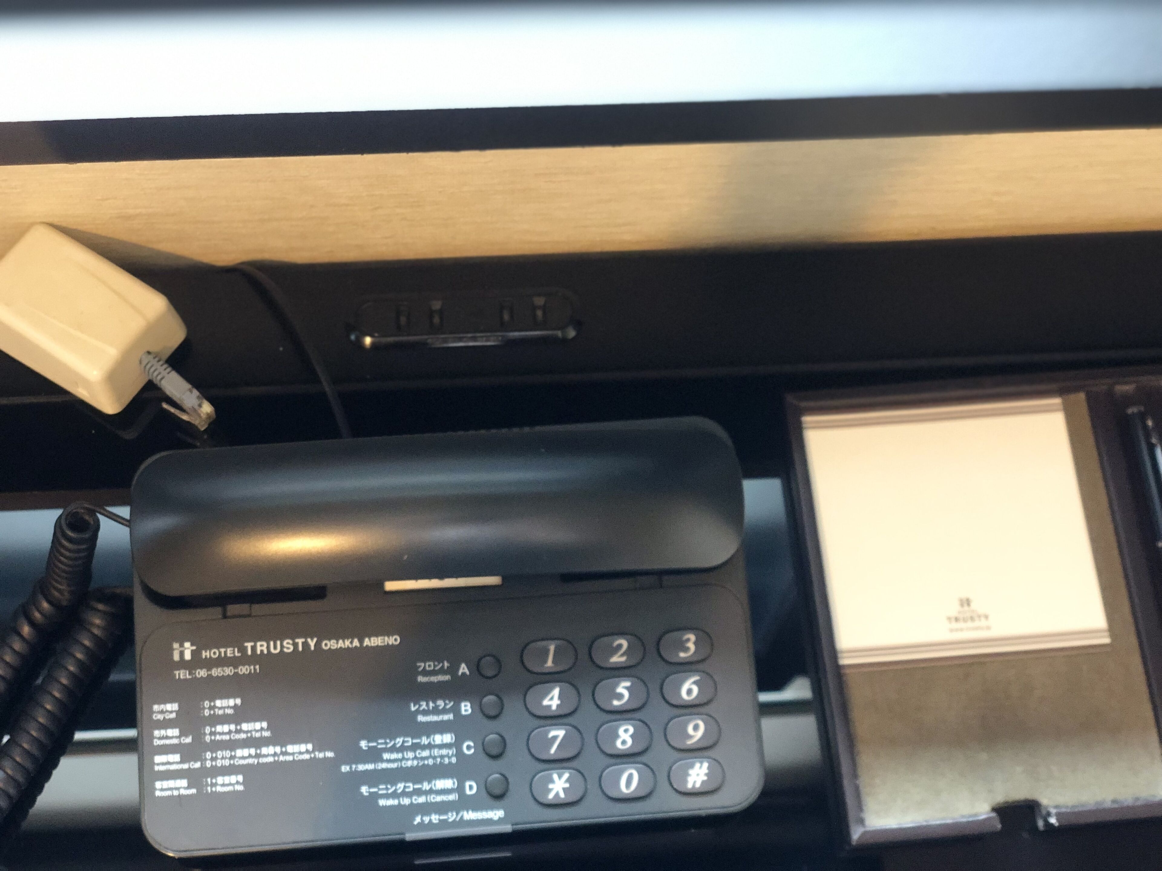 A hotel phone with a keypad and a display screen.