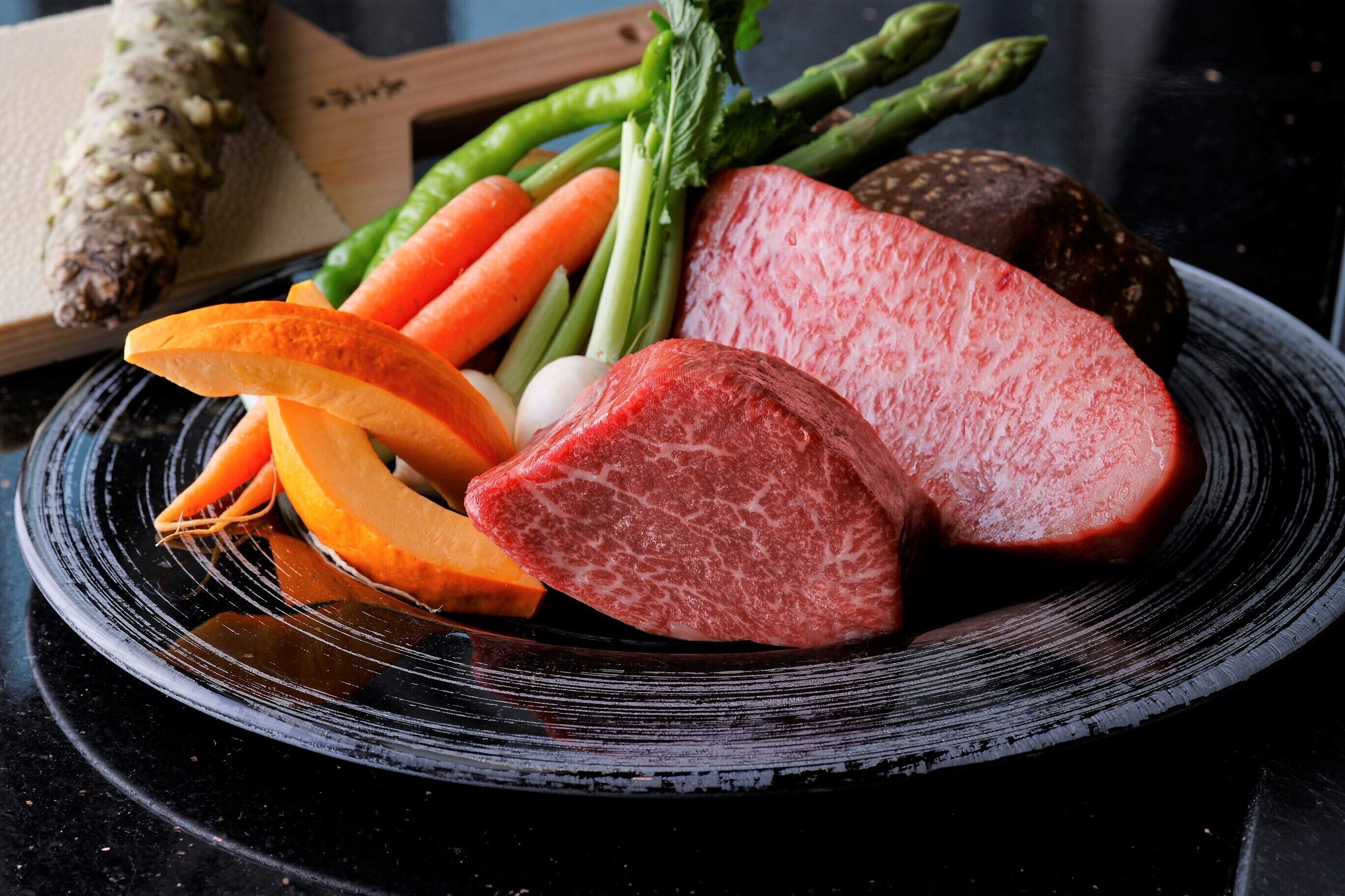 Une assiette contenant divers aliments, notamment des tranches de viande, des carottes, des haricots verts et un légume entier.