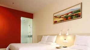 A hotel room with two beds, a painting on the wall, and a red accent wall. - Hanting Express Gangwan Square - Dalian (Dalian)