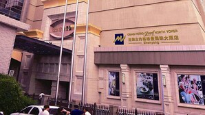 A tall hotel building with multiple floors and a prominent entrance. - Grand Metropark Hotel Shenyang (Shenyang)