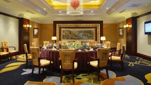 A conference room with a round table, chairs, a chandelier, and a painting on the wall. - Grand Metropark Hotel Shenyang (Shenyang)