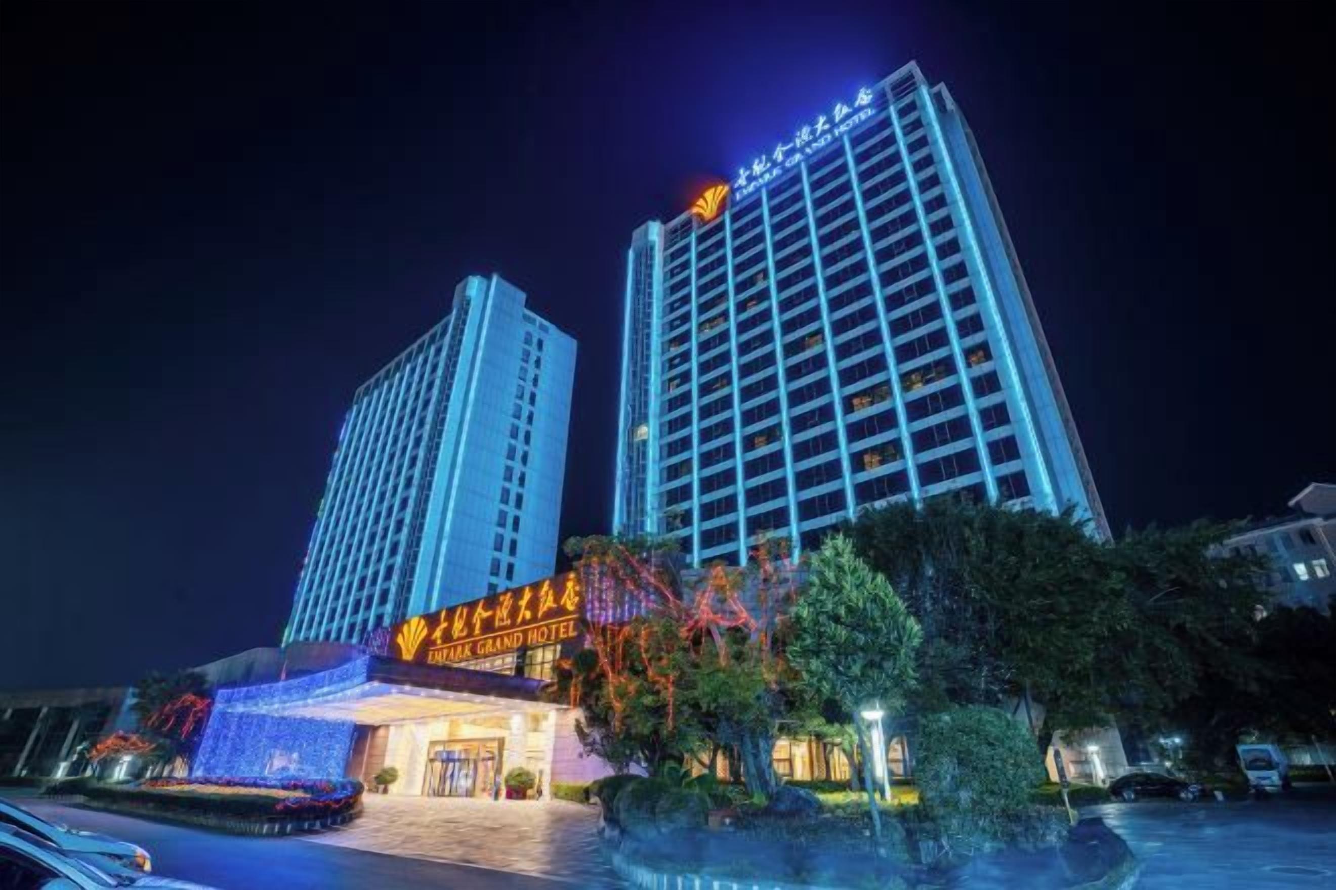 A hotel with a prominent entrance, multiple floors, and a parking area.