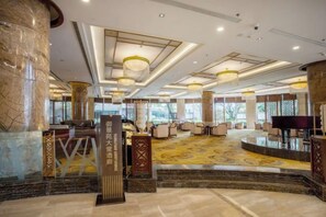 A spacious lobby with a marble floor, a reception desk, and a piano. - Empark Grand Hotel Tengchong (Baoshan)