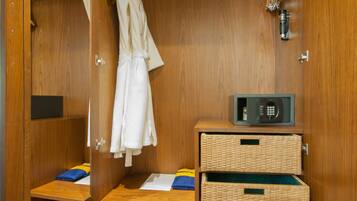 A wooden walk-in closet with a robe hanging, a microwave, and two wicker baskets.