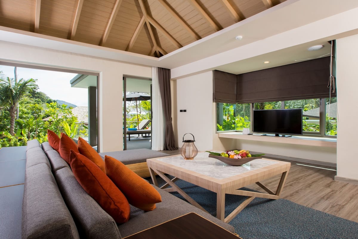 A modern living room with a sofa, a coffee table, and a television.
