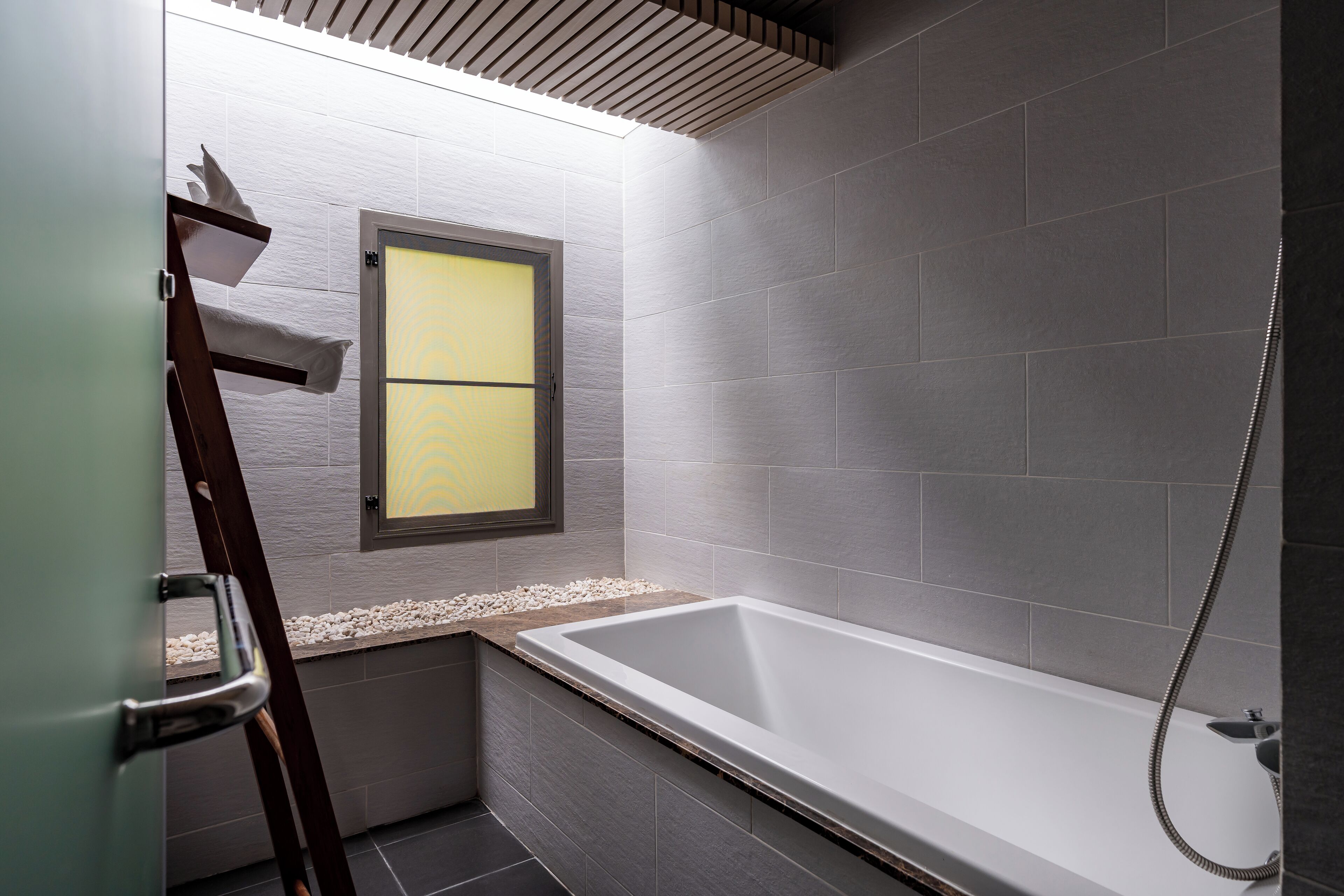 Un baño moderno con bañera, una ventana con vidrio esmerilado y zona de ducha.