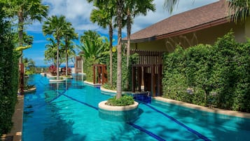 A swimming pool with palm trees and a building in the background.