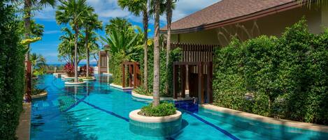 A swimming pool with palm trees and a building in the background.