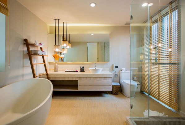 A modern bathroom with a freestanding bathtub, a vanity with a large mirror, and a glass-enclosed shower area.