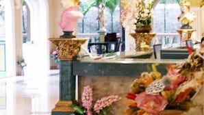 A luxurious interior with ornate decor, including a sofa, vases, and statues.
