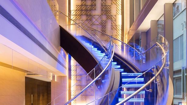 A modern spiral staircase with glass railings and illuminated steps. - Hotel Indigo Hong Kong Island by IHG (Hong Kong)