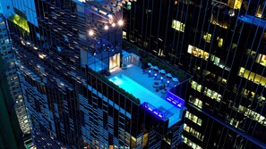 A high-rise building with a rooftop pool area featuring sun loungers and a small seating area. - Hotel Indigo Hong Kong Island by IHG (Hong Kong)