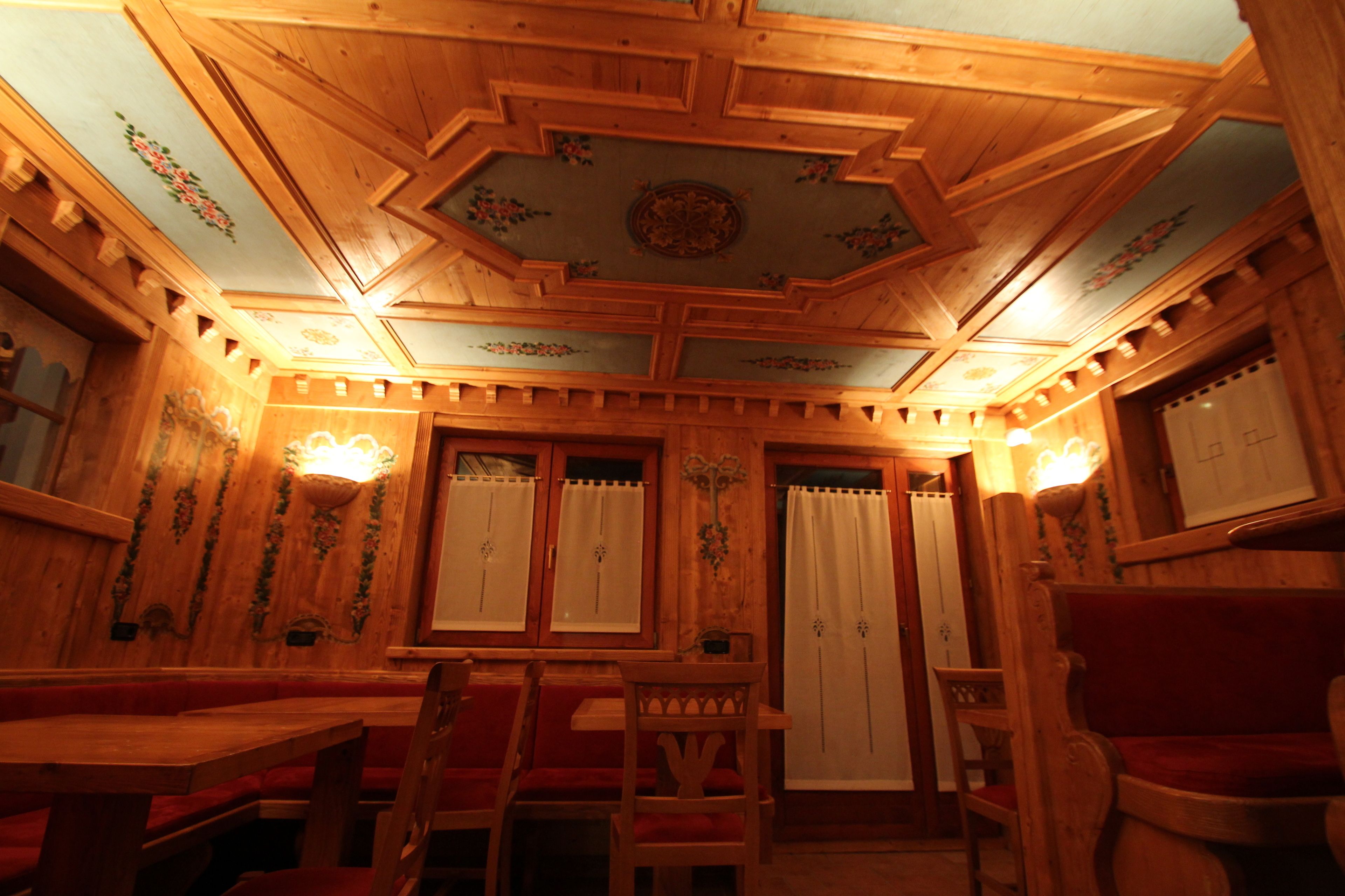 Un interno in legno con soffitto alto, panche di legno e un tavolo.